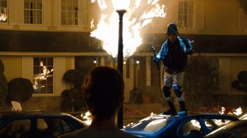 Movie still from “Project X” (2012), directed by Nima Nourizadeh – A man in a blue jacket is on a fire hydrant; Wide shot, Over the shoulder angle