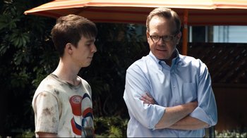 Movie still from “Project X” (2012), directed by Nima Nourizadeh – A man standing next to a young boy with his arms crossed; Close Up shot, Over the shoulder angle