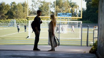 Movie still from “Project X” (2012), directed by Nima Nourizadeh – A man and a woman are standing in front of a football field; Wide shot, Over the shoulder angle