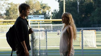 Movie still from “Project X” (2012), directed by Nima Nourizadeh – A man and a woman are standing in front of a chain link fence; Medium shot, Over the shoulder angle