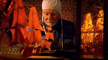 Movie still from “Prospero's Books” (1991), directed by Peter Greenaway – An older man is looking at a model ship; Medium shot, Low angle