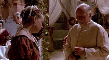 Movie still from “Prospero's Books” (1991), directed by Peter Greenaway – A man and a woman standing next to each other in a room; Medium shot, High angle