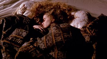 Movie still from “Prospero's Books” (1991), directed by Peter Greenaway – A woman laying in bed with her head on a pillow; Medium shot, Overhead angle