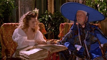 A woman sitting at a table with a man in a blue hat