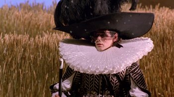 Movie still from “Prospero's Books” (1991), directed by Peter Greenaway – A man wearing a black hat and a white and black outfit; Medium shot, Low angle