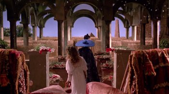 Movie still from “Prospero's Books” (1991), directed by Peter Greenaway – Two people walking through a room with arches and flowers; Wide shot, High angle