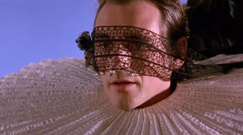 Movie still from “Prospero's Books” (1991), directed by Peter Greenaway – A person wearing a lace mask; Close Up shot, Low angle