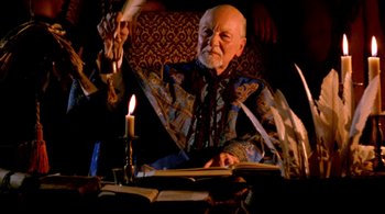 An old man sitting at a table reading a book