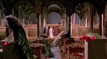 Movie still from “Prospero's Books” (1991), directed by Peter Greenaway – A group of people standing in a room with hay bales; Extreme Wide shot, High angle