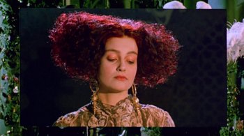 Movie still from “Prospero's Books” (1991), directed by Peter Greenaway – A woman with red curly hair is wearing gold earrings; Close Up shot, Low angle