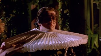 Movie still from “Prospero's Books” (1991), directed by Peter Greenaway – A man wearing a mask and holding a paper fan; Close Up shot, Low angle