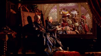 Movie still from “Prospero's Books” (1991), directed by Peter Greenaway – A group of people sitting in a room; Wide shot, Low angle