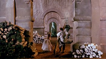 Movie still from “Prospero's Books” (1991), directed by Peter Greenaway – A man and a woman are in a stone room; Wide shot, High angle