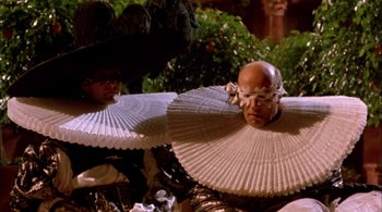 Movie still from “Prospero's Books” (1991), directed by Peter Greenaway – A man with a pair of paper fans on his head; Medium shot, Low angle