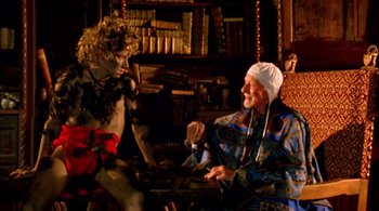 Movie still from “Prospero's Books” (1991), directed by Peter Greenaway – A man sitting next to another man in a room; Medium shot, High angle