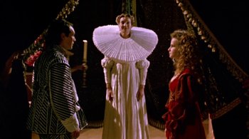 Movie still from “Prospero's Books” (1991), directed by Peter Greenaway – A man and two women standing next to each other; Medium shot, Low angle