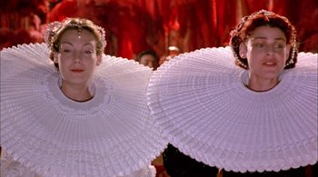 Movie still from “Prospero's Books” (1991), directed by Peter Greenaway – Two women in white dresses holding white fans in front of a red background; Close Up shot, Low angle