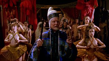 Movie still from “Prospero's Books” (1991), directed by Peter Greenaway – An old man with a white beard and a white hat holding a cane; Medium shot, High angle