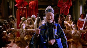 Movie still from “Prospero's Books” (1991), directed by Peter Greenaway – An old man with a beard and a hat is holding a staff; Medium shot, High angle