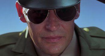 Movie still from “Psycho” (1998), directed by Gus Van Sant – A person wearing sunglasses and a hat; Close Up shot, Low angle