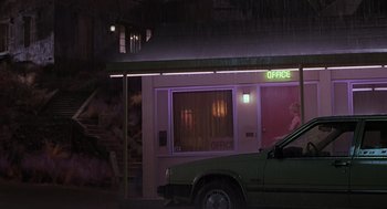 Movie still from “Psycho” (1998), directed by Gus Van Sant – A woman sitting in the driver's seat of a green truck; Extreme Wide shot, Low angle
