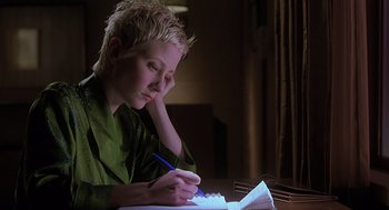 Movie still from “Psycho” (1998), directed by Gus Van Sant – A person sitting at a table writing on a piece of paper; Close Up shot, High angle