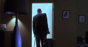 Movie still from “Psycho” (1998), directed by Gus Van Sant – An older man standing in front of a door; Wide shot, Low angle