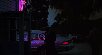 Movie still from “Psycho” (1998), directed by Gus Van Sant – A man standing next to a purple car at night; Wide shot, Low angle