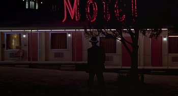 Movie still from “Psycho” (1998), directed by Gus Van Sant – A man standing in front of a motel at night; Wide shot, Low angle