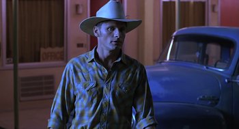 Movie still from “Psycho” (1998), directed by Gus Van Sant – A man wearing a cowboy hat standing next to a car; Medium shot, Over the shoulder angle