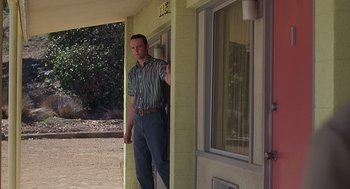 Movie still from “Psycho” (1998), directed by Gus Van Sant – A man standing on the porch of a house; Wide shot, Low angle