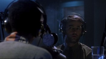 Movie still from “Psycho IV: The Beginning” (1990), directed by Mick Garris – A man wearing headphones and talking into a microphone; Close Up shot, Over the shoulder angle