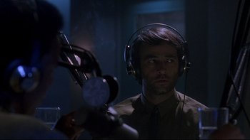 Movie still from “Psycho IV: The Beginning” (1990), directed by Mick Garris – A man wearing headphones and looking at the camera; Close Up shot, Over the shoulder angle