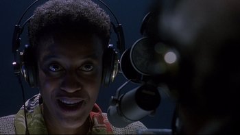 Movie still from “Psycho IV: The Beginning” (1990), directed by Mick Garris – A man with headphones on looking into a camera; Close Up shot, Low angle