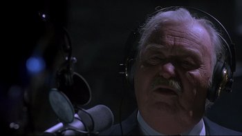Movie still from “Psycho IV: The Beginning” (1990), directed by Mick Garris – An older man with a beard and mustache wearing a microphone; Close Up shot, Low angle