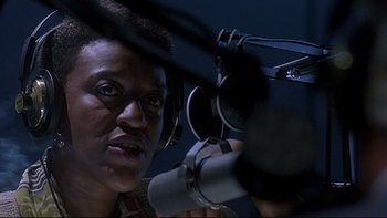 Movie still from “Psycho IV: The Beginning” (1990), directed by Mick Garris – A person with a microphone in a dark room; Close Up shot, Low angle