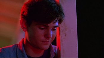 Movie still from “Psycho IV: The Beginning” (1990), directed by Mick Garris – A young man is looking down at his face; Close Up shot, Low angle