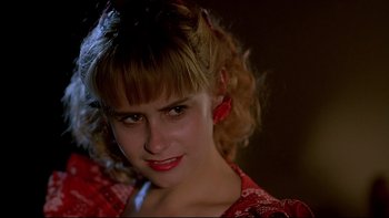 Movie still from “Psycho IV: The Beginning” (1990), directed by Mick Garris – A young woman with blonde curly hair wearing a red dress; Close Up shot, Low angle