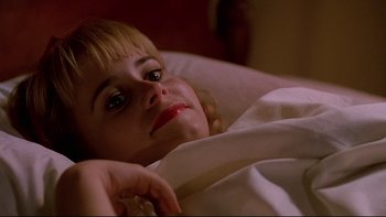 Movie still from “Psycho IV: The Beginning” (1990), directed by Mick Garris – A woman laying in a bed with her hand on her chin; Close Up shot, High angle