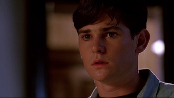 Movie still from “Psycho IV: The Beginning” (1990), directed by Mick Garris – A person wearing a black shirt; Close Up shot, Over the shoulder angle