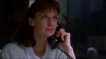 Movie still from “Psycho IV: The Beginning” (1990), directed by Mick Garris – A woman talking on a phone while sitting in a room; Close Up shot, Low angle