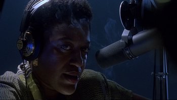 Movie still from “Psycho IV: The Beginning” (1990), directed by Mick Garris – A man wearing headphones and a microphone in a recording studio; Close Up shot, Low angle