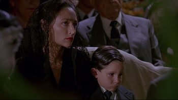 Movie still from “Psycho IV: The Beginning” (1990), directed by Mick Garris – A woman sitting next to a young boy in a suit; Close Up shot, Low angle