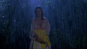 Movie still from “Psycho IV: The Beginning” (1990), directed by Mick Garris – A woman holding a yellow umbrella standing in the rain; Medium shot, Low angle