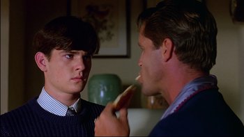 Movie still from “Psycho IV: The Beginning” (1990), directed by Mick Garris – A man feeding a piece of food to another man; Close Up shot, Over the shoulder angle