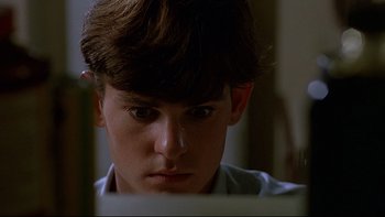 Movie still from “Psycho IV: The Beginning” (1990), directed by Mick Garris – A young man looking at a computer screen; Close Up shot, Low angle