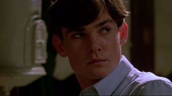 Movie still from “Psycho IV: The Beginning” (1990), directed by Mick Garris – A young man with short brown hair wearing a dress shirt; Close Up shot, Low angle