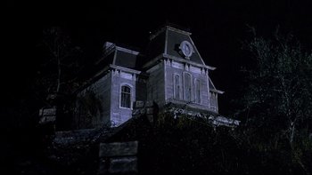 Movie still from “Psycho IV: The Beginning” (1990), directed by Mick Garris – An old building with a clock on the front of it; Extreme Wide shot, Low angle