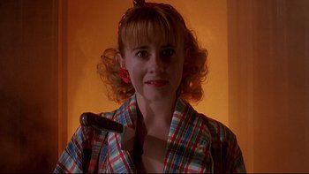 Movie still from “Psycho IV: The Beginning” (1990), directed by Mick Garris – A woman holding a hammer in a room; Close Up shot, Low angle