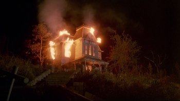 Movie still from “Psycho IV: The Beginning” (1990), directed by Mick Garris – A house that is on fire at night time; Extreme Wide shot, Low angle